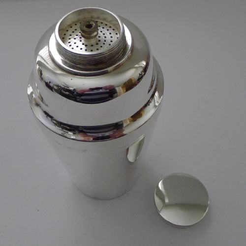 fig 1. A polished silver-plated Art Deco cocktail shaker with a stepped lid and tapered cylindrical body.