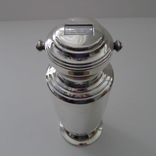fig 2. A silver-plated Art Deco cocktail shaker featuring a rotating top cap with rectangular windows displaying drink recipes.