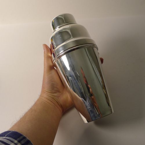 fig 1. A polished silver-plated Art Deco cocktail shaker featuring a tapered body and stepped lid structure.