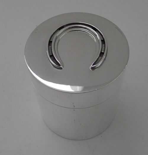 fig 3. A vintage sterling silver smoking compendium set featuring four horseshoe-shaped ashtrays and a central cylinder within an open silk-lined presentation case.