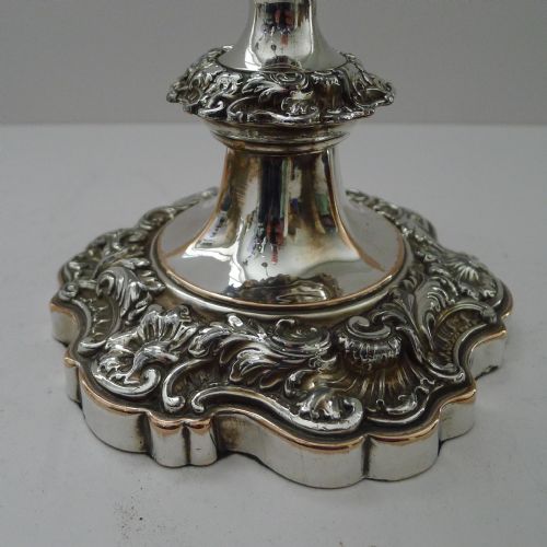 fig 1. A pair of ornate silver-plated multi-branch candelabra featuring scrolled foliage arms and decorative stepped bases.