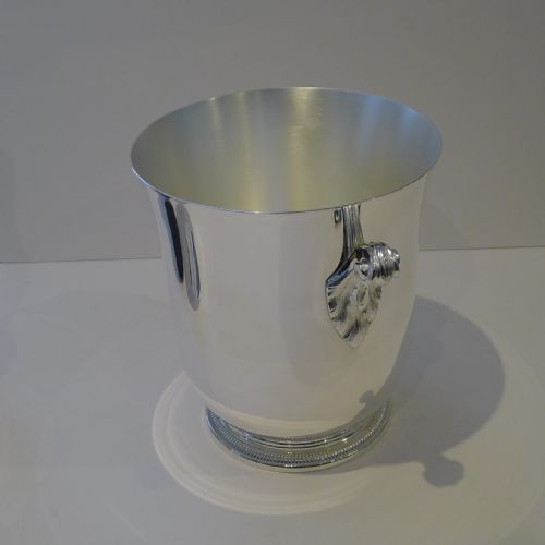 fig 1. A polished silver-plated French champagne bucket featuring dual scroll side handles and a detailed beaded rim around the circular base.
