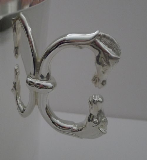fig 1. A polished silver-plated champagne bucket featuring twin side handles shaped as detailed horse heads.