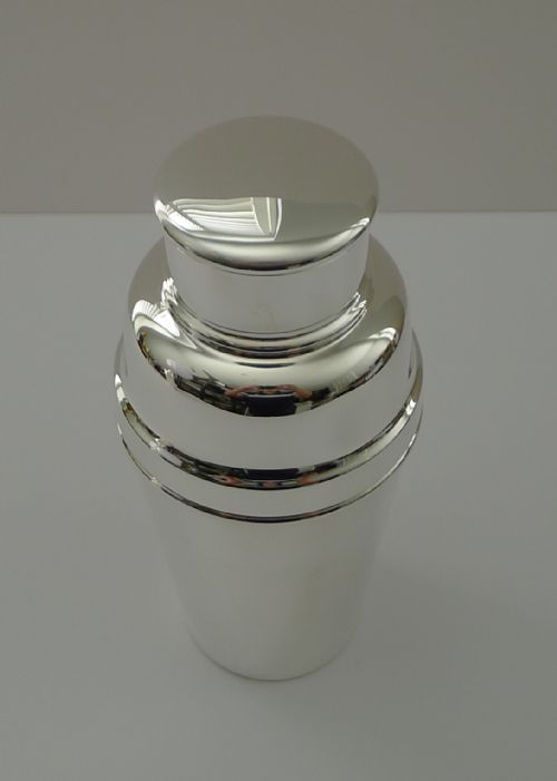 fig 1. A polished silver-plated Art Deco cocktail shaker featuring a tapered smooth body and a stepped removable cap.