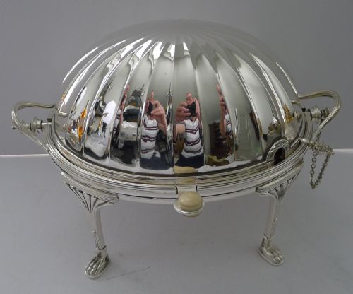 fig 1. A Victorian silver-plated revolving breakfast dish featuring a fluted domed cover, twin side handles, and four cast claw legs.