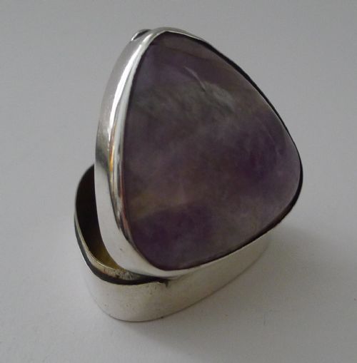 fig 1. A triangular sterling silver pill box fitted with a smooth purple amethyst cabochon lid.