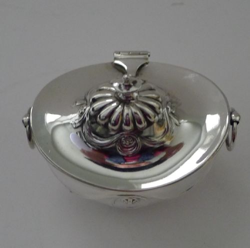 fig 2. An antique Edwardian sterling silver tea caddy featuring lower fluted detailing, embossed swag motifs, drop ring handles, and a finial lid.