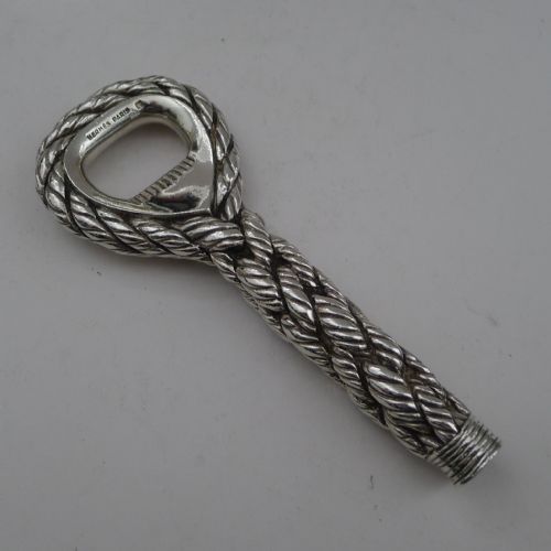 fig 1. A silver-plated bottle opener featuring a detailed twisted cordage rope handle and a stamped maker mark inside the opener head.