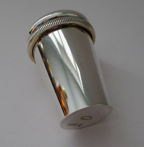 fig 3. An Edwardian sterling silver travelling medical kit featuring a silver outer sleeve, etched glass dose beaker, and gilded screw caps.