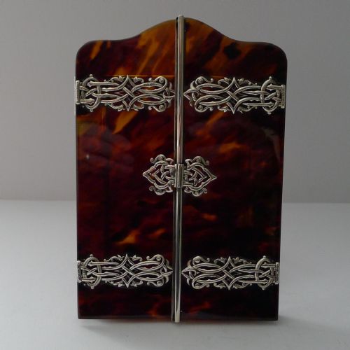 fig 1. A late 19th-century Victorian tortoiseshell photograph frame featuring arched folding doors, pierced sterling silver mounts, and a silver easel back.