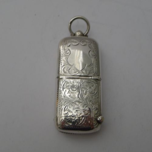 fig 1. An open Edwardian sterling silver combined sovereign holder and vesta case with hand-engraved foliate patterns and a suspension ring.