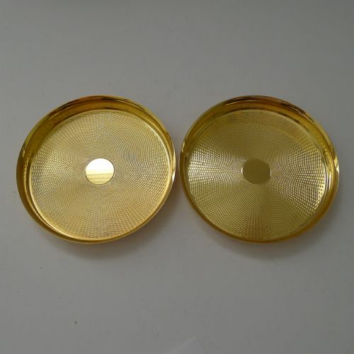 fig 1. A pair of round gold-coloured vermeil silver gilt coasters featuring engine-turned textured centres and smooth raised rims.