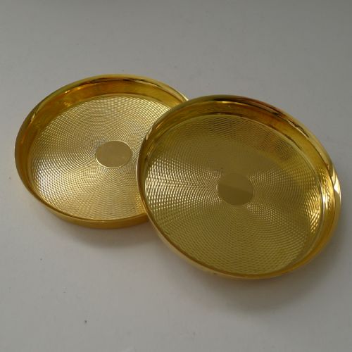 fig 2. A pair of round gold-coloured vermeil silver gilt coasters featuring engine-turned textured centres and smooth raised rims.