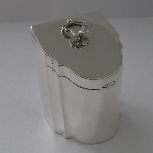 fig 1. A polished sterling silver tea caddy designed in the form of a Georgian knife box with a sloped hinged lid and cast loop handle.
