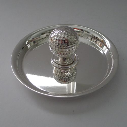 fig 1. A circular silver-plated shallow dish featuring a central sculpted golf ball handle with a dimpled surface.