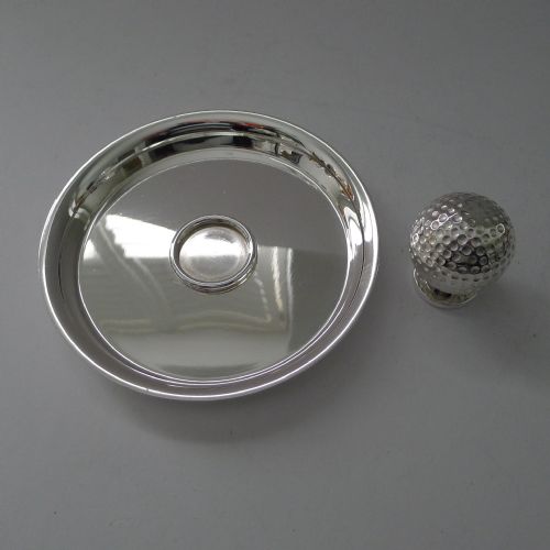 fig 3. A circular silver-plated shallow dish featuring a central sculpted golf ball handle with a dimpled surface.