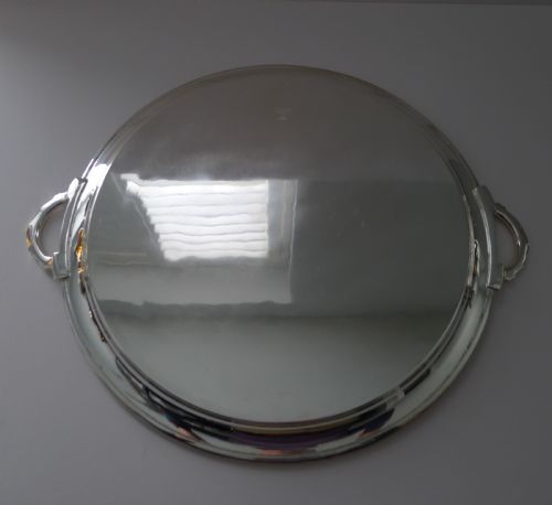 fig 1. A circular silver-plated Art Deco cocktail tray featuring concentric line engraving on the flat surface and two stylized side handles.