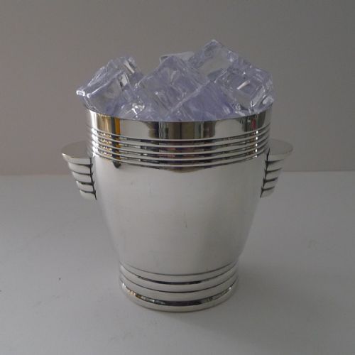 fig 1. A silver-plated Art Deco ice bucket featuring a tapered silhouette, horizontal ribbed bands, and stylized stepped side handles.