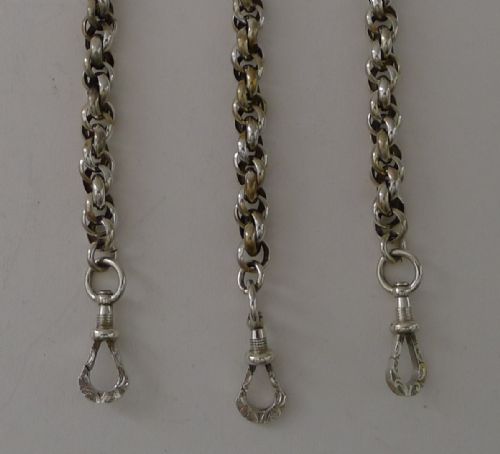 fig 1. A Victorian sterling silver chatelaine featuring an ornate pierced scroll waist clip suspending five linked chains attached to silver accessories including a scent bottle, card case, pencil, and thimble holder.