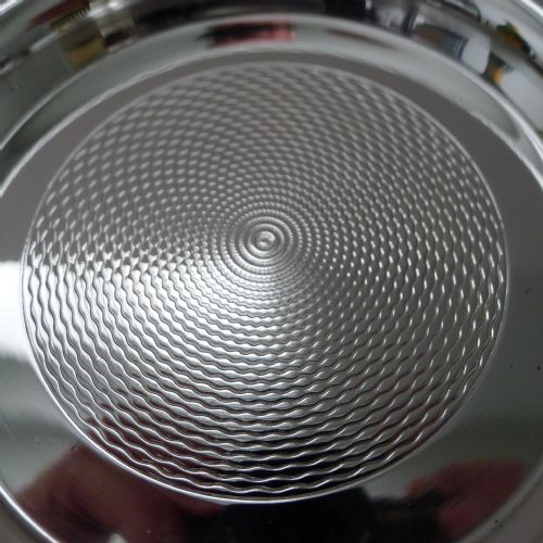 fig 5. A pair of circular silver-plated coasters featuring raised rims and engine-turned concentric circle patterns.