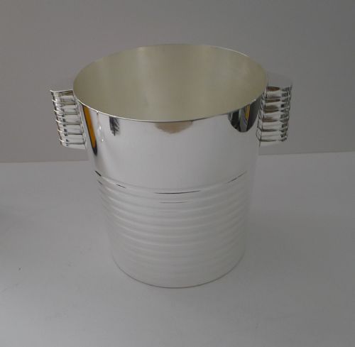 fig 1. An Art Deco silver-plated champagne cooler featuring horizontal ridged bands and tiered side handles.