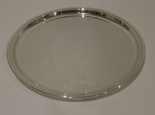 fig 1. A circular silver-plated drinks tray featuring a flat polished center surface and a stepped moulded rim.