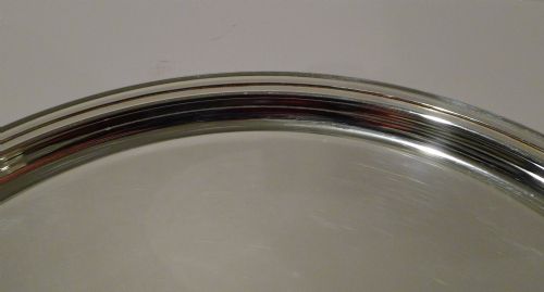 fig 2. A circular silver-plated drinks tray featuring a flat polished center surface and a stepped moulded rim.