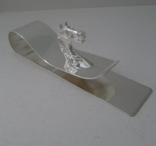 fig 2. A polished silver-plated bent metal desk clip featuring a detailed sculpted horse head motif.