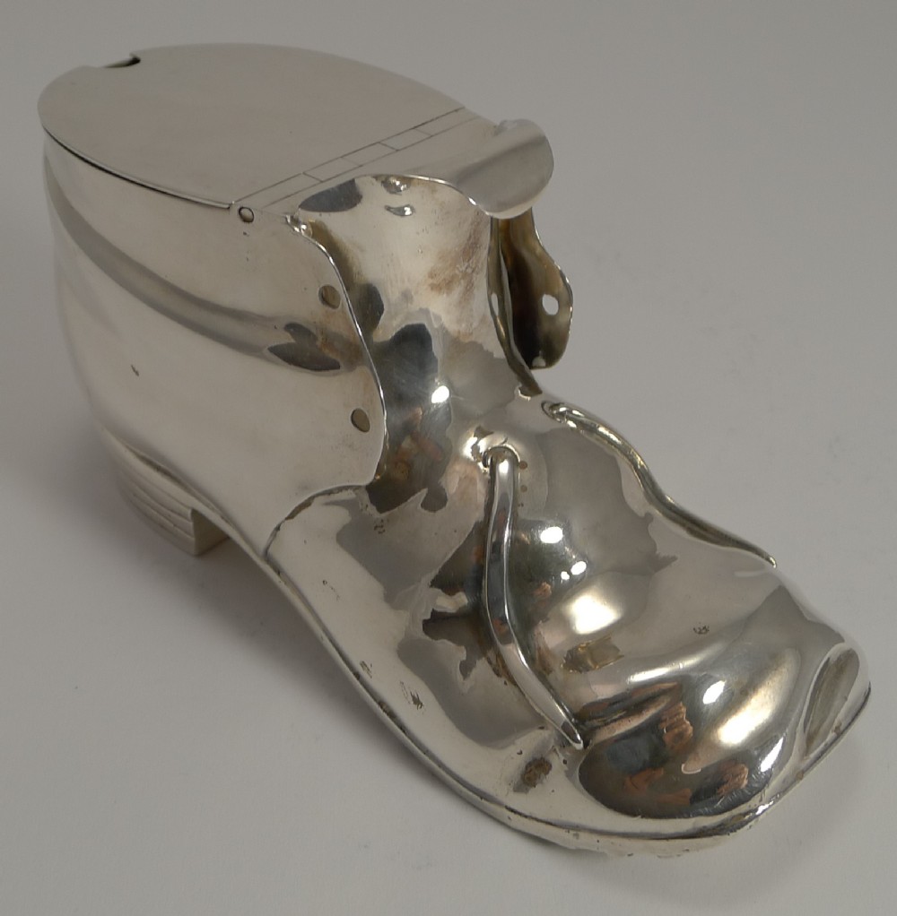 A Victorian silver-plated novelty spoon warmer designed in the form of a laced shoe with a hinged opening lid.