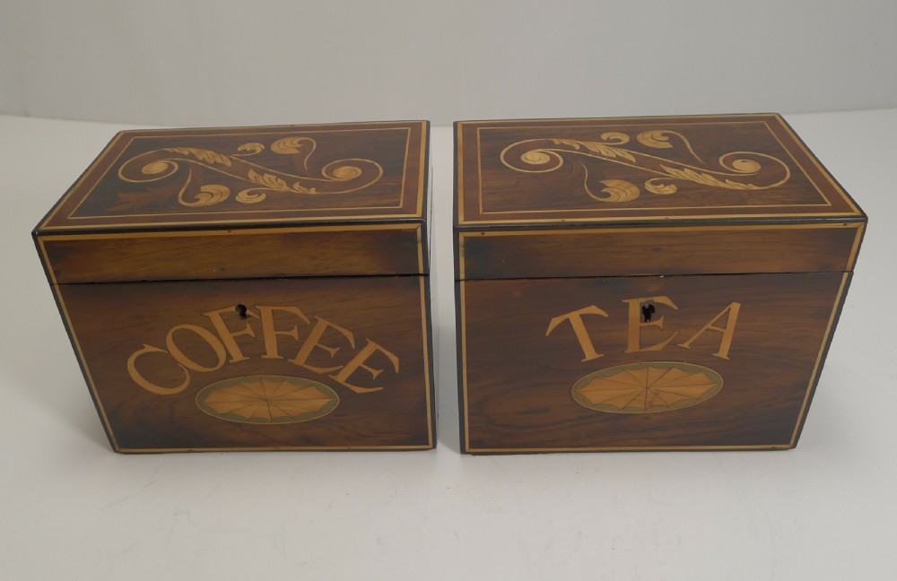 A pair of dark wood Victorian tea and coffee caddies featuring scroll marquetry on the lids and inlaid lettering on the front.