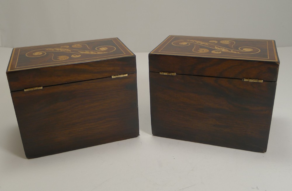 A pair of dark wood Victorian tea and coffee caddies featuring scroll marquetry on the lids and inlaid lettering on the front. View VI