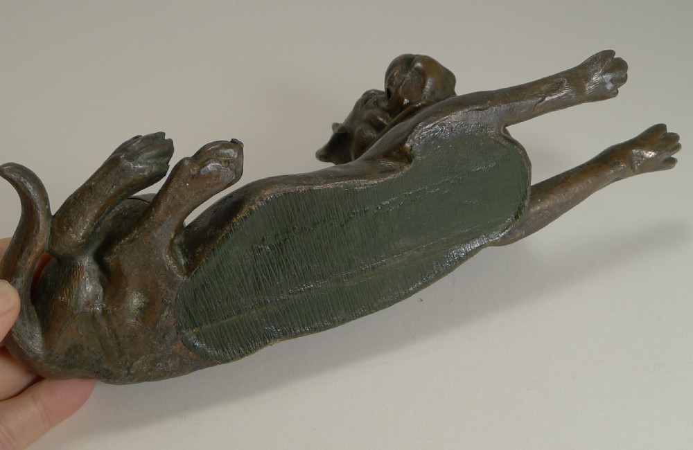 A dark brown patinated bronze inkwell sculpted in the shape of a lying Bullmastiff holding a dip pen in its mouth. View VI