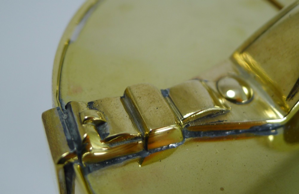 A polished brass novelty biscuit box fashioned in the shape of a hat box with a top handle, latch fastening, and accompanying small padlock with key. View IX