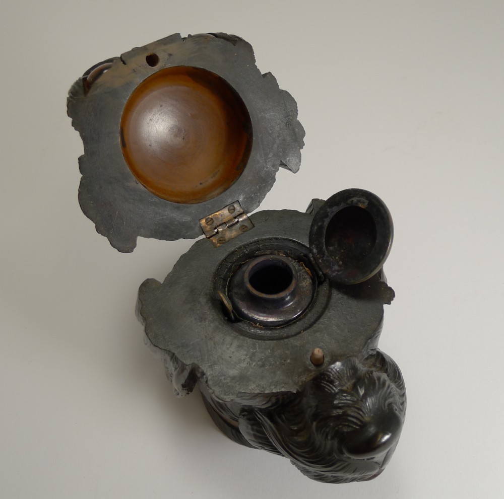 A 19th-century hand-carved dark wood inkwell crafted in the shape of a dog head with inset amber glass eyes. View XI