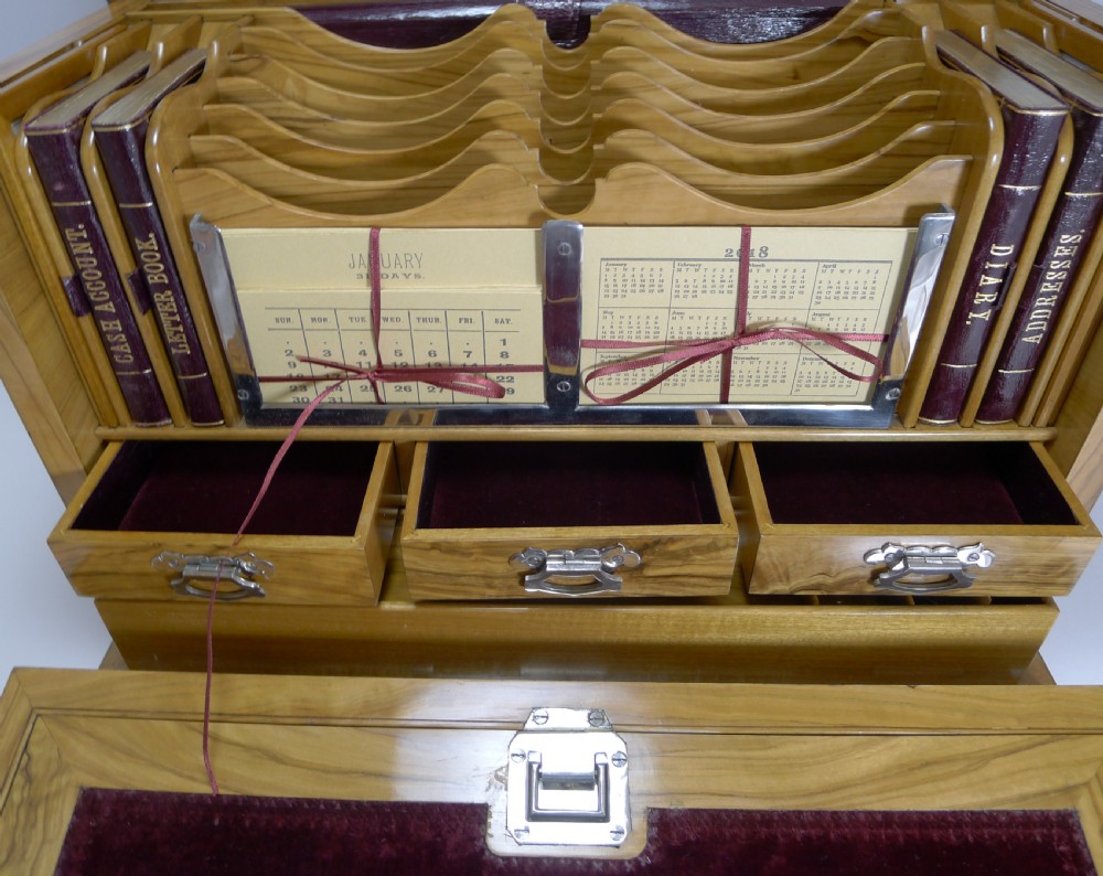 An open Victorian olivewood writing box cabinet displaying a burgundy velvet fold-out slope, internal drawers, stationery slots, and desk accessories. View VIII