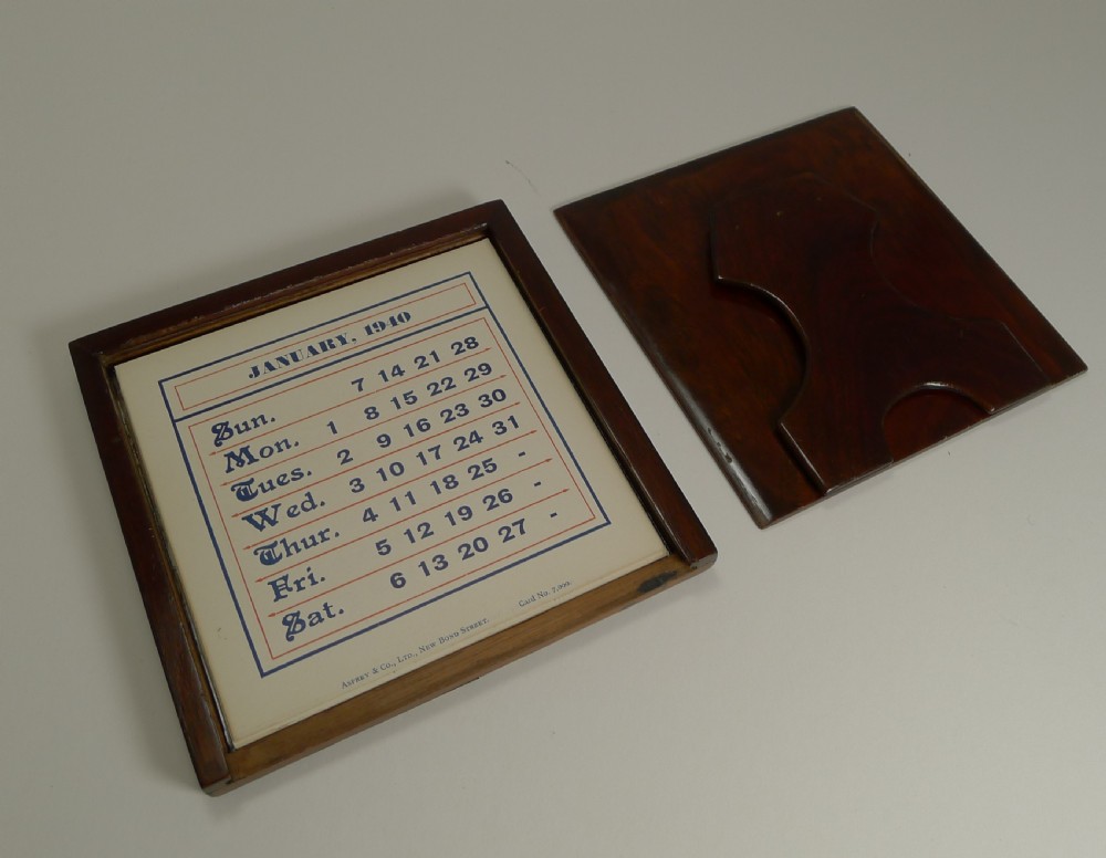 An antique square desk calendar framed in dark tortoiseshell with intricate brass foliate scroll inlay, displaying a printed date card for June 1940. View VII