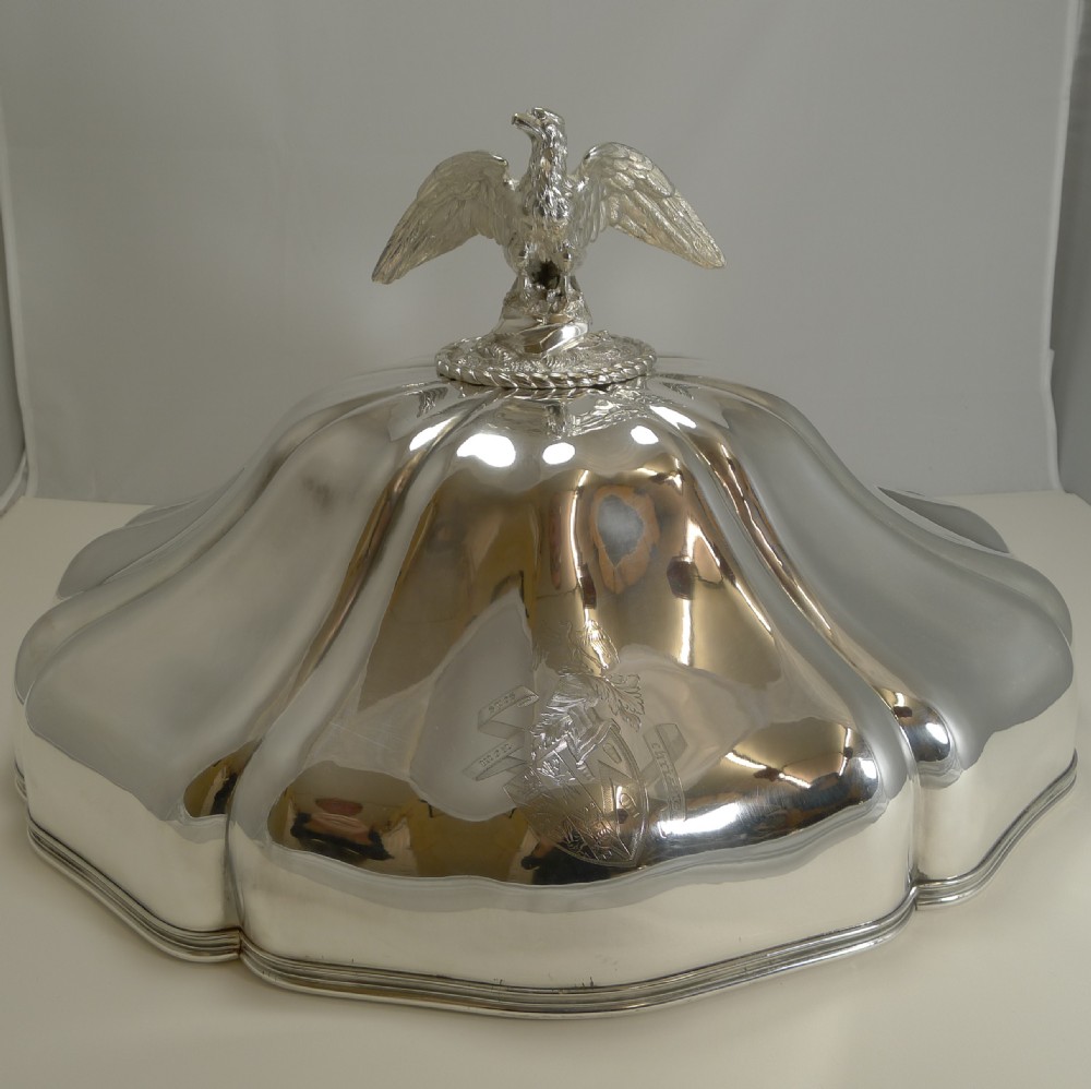 A set of three graduated silver meat domes with lobed bodies and detailed eagle finials. View III
