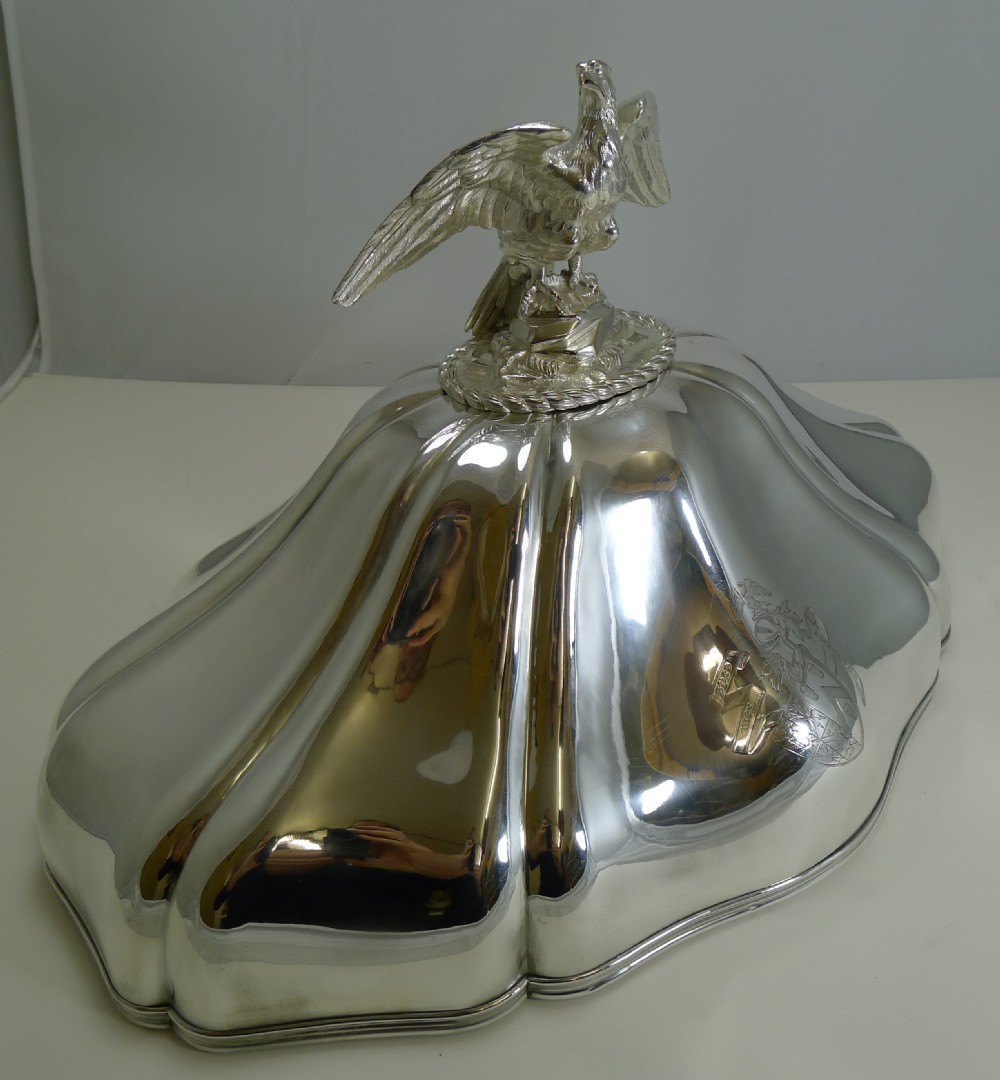 A set of three graduated silver meat domes with lobed bodies and detailed eagle finials. View XI