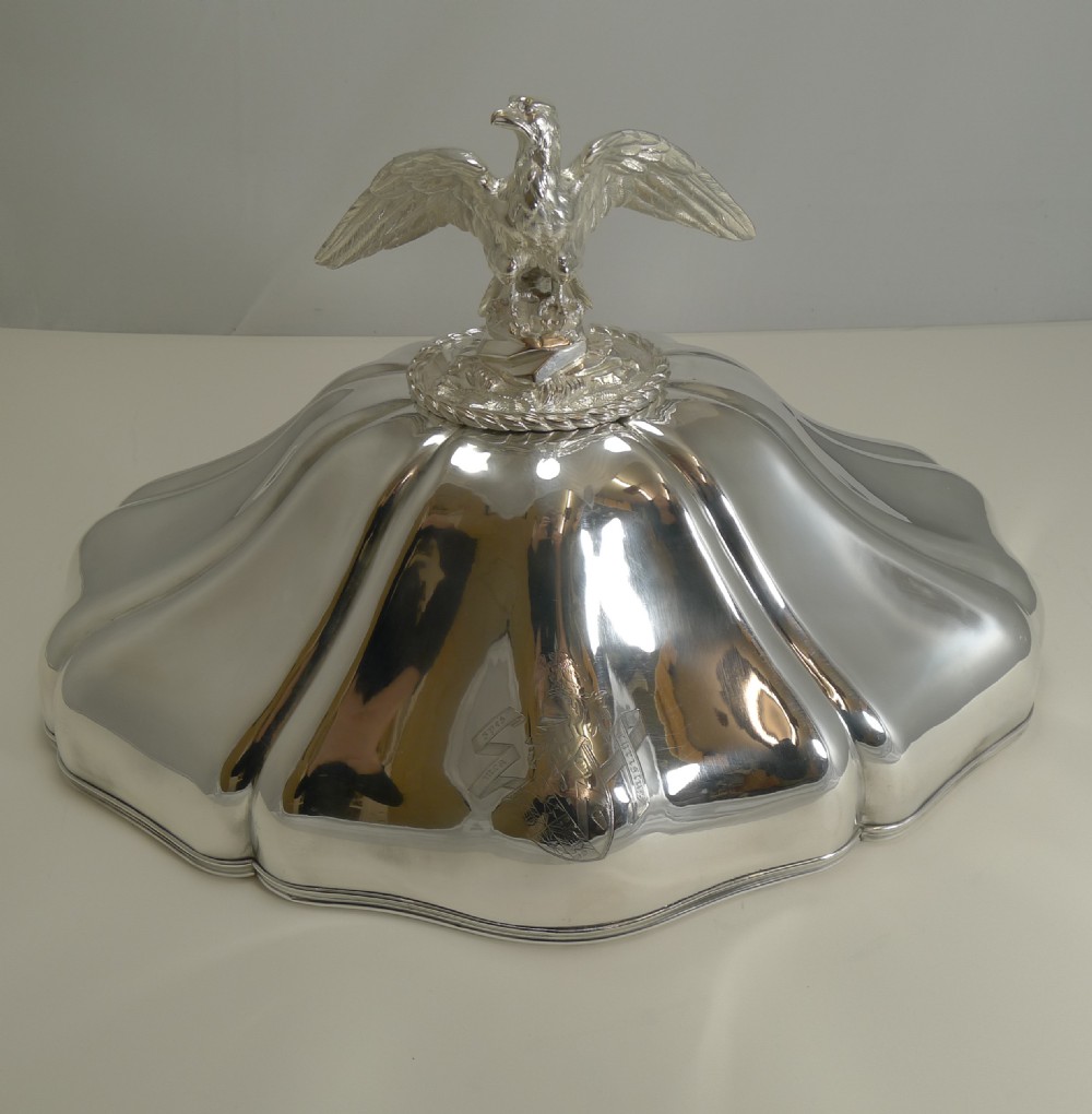 A set of three graduated silver meat domes with lobed bodies and detailed eagle finials. View XII