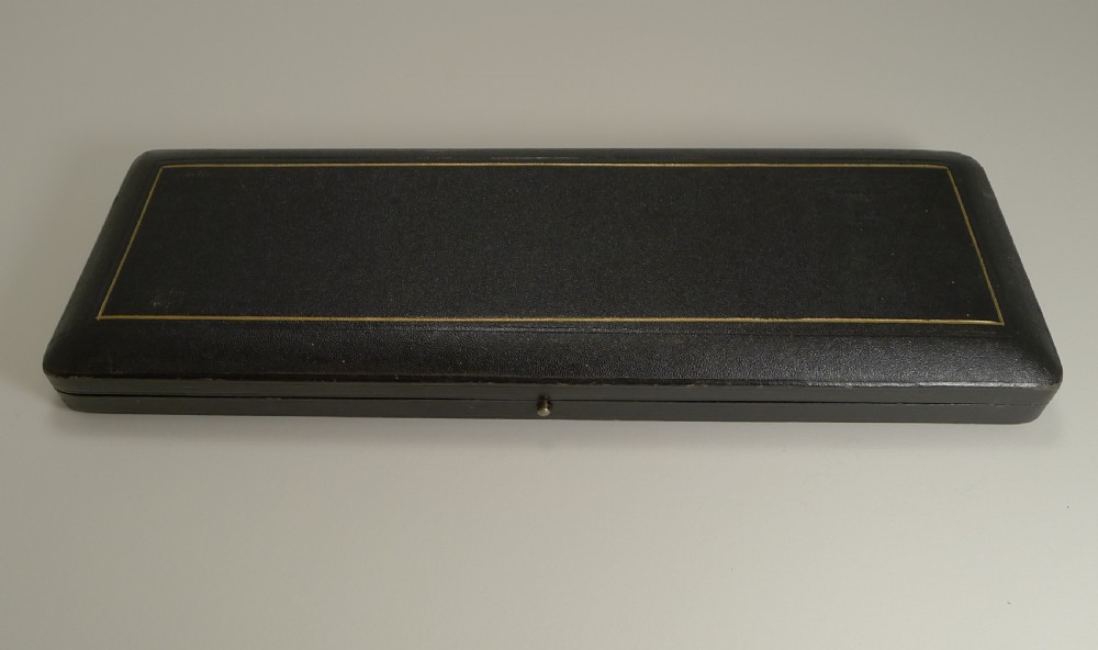 A cased pair of late Victorian fish servers featuring engraved silver-plated blades with hunting dog motifs and fluted horn handles. View II