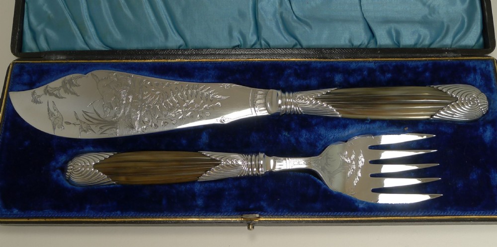 A cased pair of late Victorian fish servers featuring engraved silver-plated blades with hunting dog motifs and fluted horn handles. View III