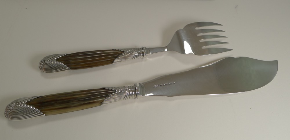 A cased pair of late Victorian fish servers featuring engraved silver-plated blades with hunting dog motifs and fluted horn handles. View VII