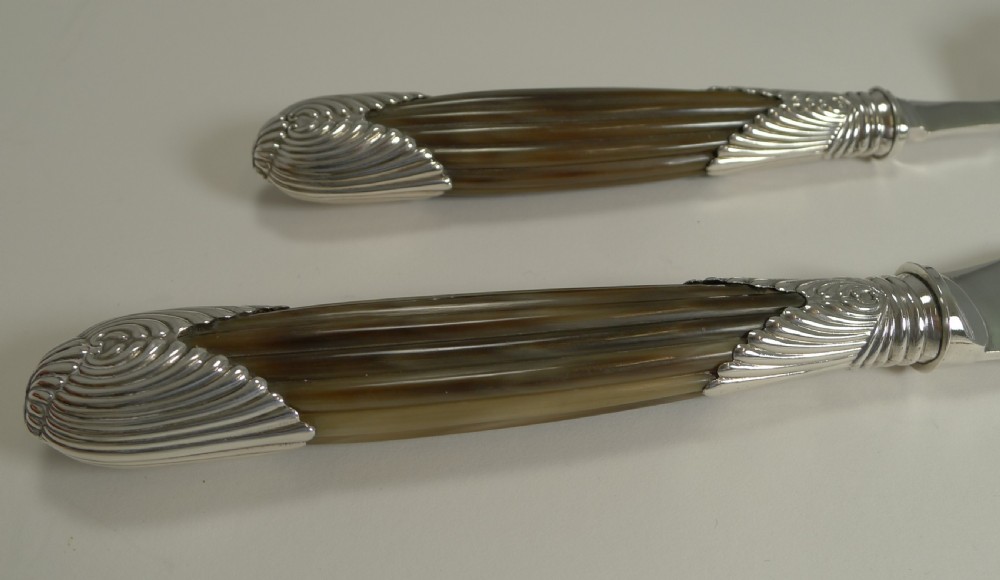 A cased pair of late Victorian fish servers featuring engraved silver-plated blades with hunting dog motifs and fluted horn handles. View VIII