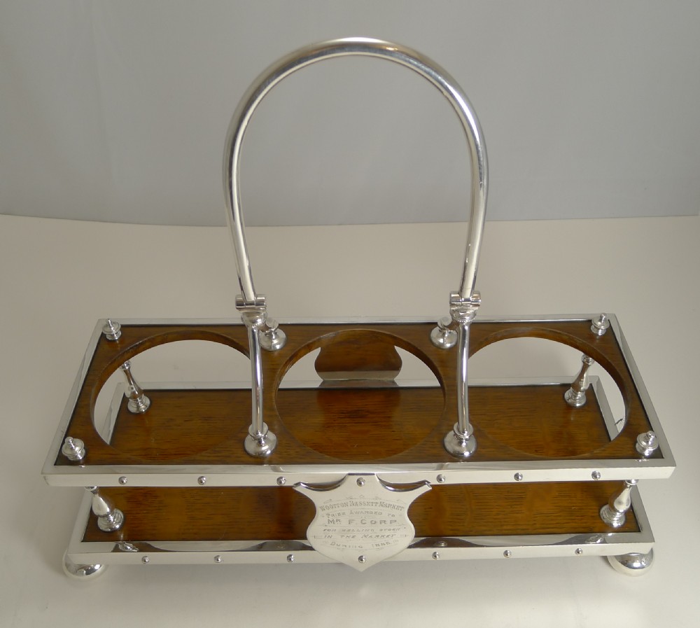 Late Victorian oak and silver-plated tantalus frame holding three cut-glass decanters with faceted stoppers. View XII