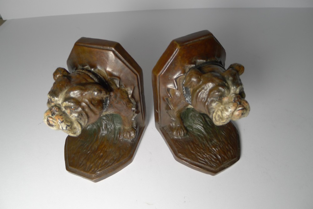 A pair of brown cold-painted bronze bookends featuring sculpted English bulldog heads and forelegs set against angled backplates. View VII