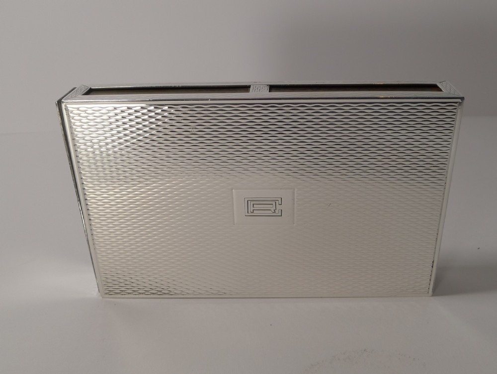 A rectangular sterling silver box with a fine engine-turned geometric pattern and a central engraved monogram. View II