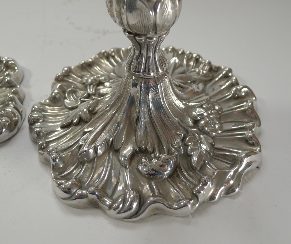 A pair of antique Art Nouveau silver candlesticks with relief leaf motifs, tapered stems, and wide wavy bases. View IV