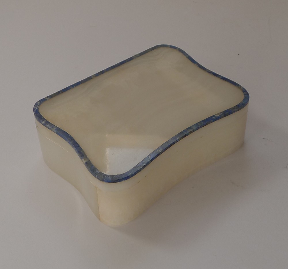 A rectangular Art Deco white onyx trinket box featuring contoured sides and an inlaid lapis lazuli border along the rim of the lid.