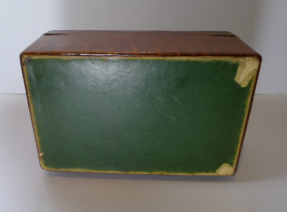 A rectangular warm brown crocodile skin jewellery box featuring a brass plaque on the lid and a lock with a key. View VII