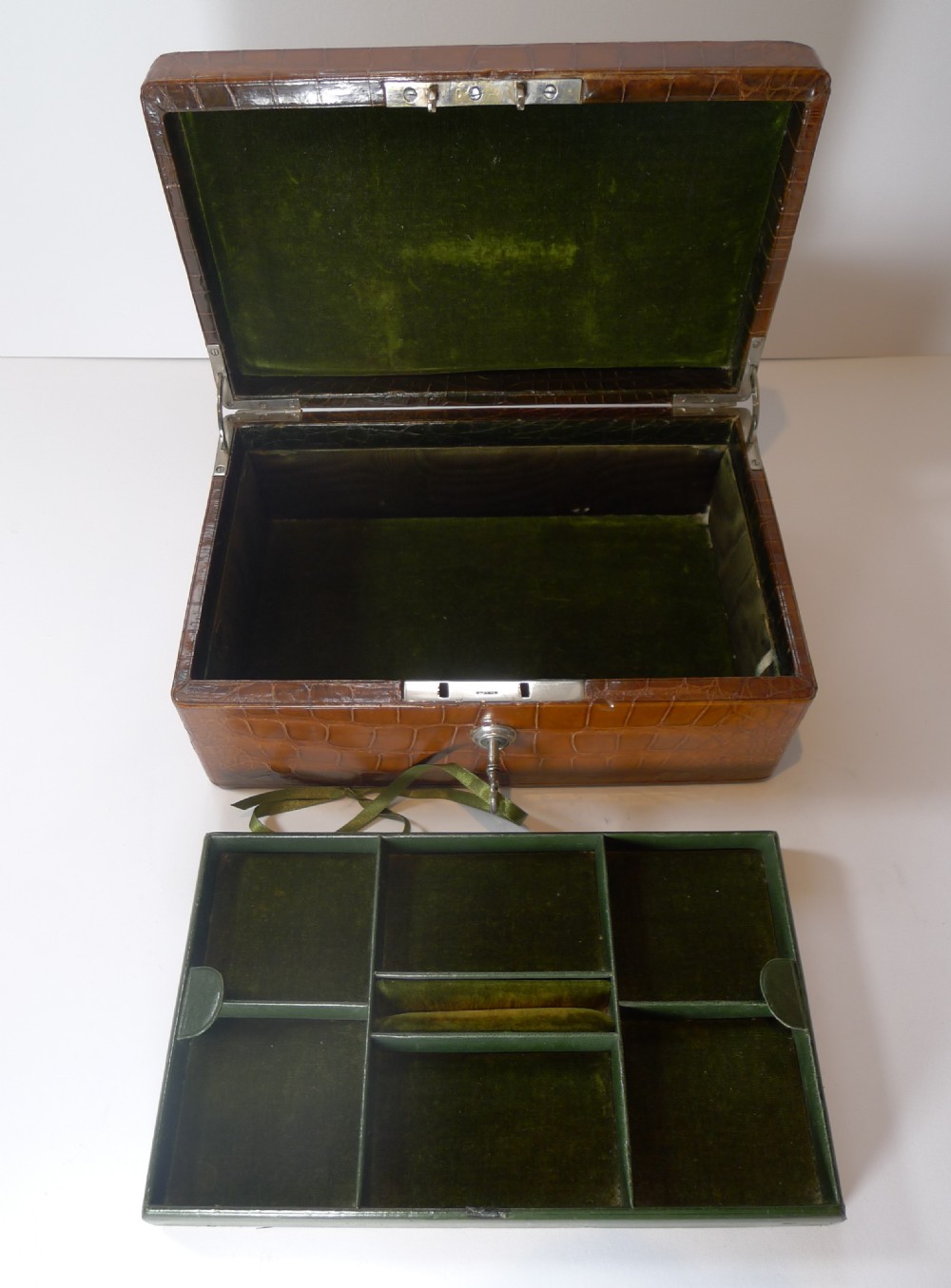 A rectangular warm brown crocodile skin jewellery box featuring a brass plaque on the lid and a lock with a key. View XI